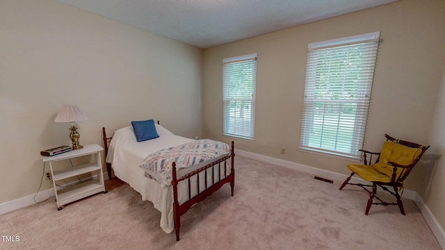bedroom with light carpet and baseboards