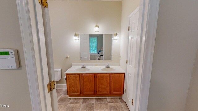 bathroom featuring double vanity and baseboards