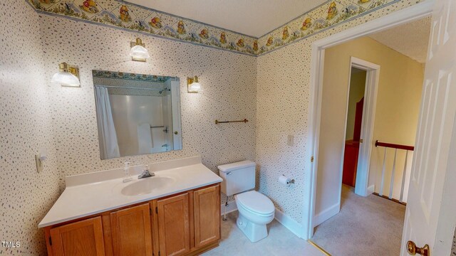 full bath with toilet, a shower with curtain, vanity, and baseboards