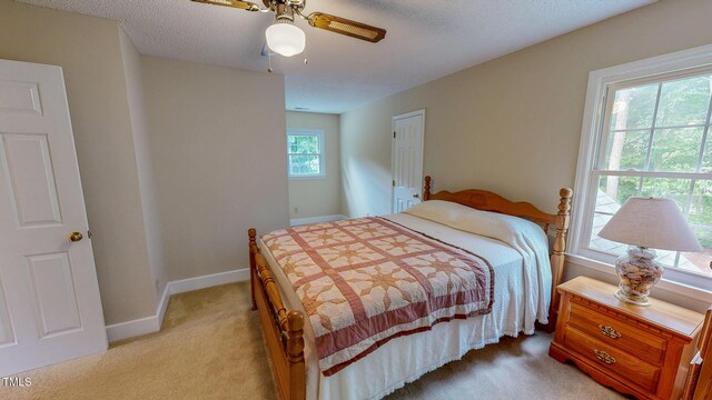 bedroom featuring light carpet, baseboards, and ceiling fan