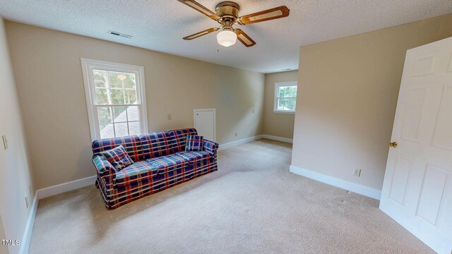 sitting room with carpet, ceiling fan, a textured ceiling, and baseboards