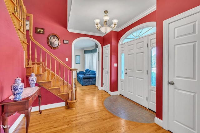107 Stargrass Ave, Clayton, NC 27527 - foyer with arched walkways, a chandelier, wood finished floors, crown molding, and stairway