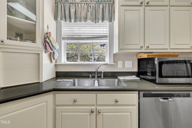 107 Stargrass Ave, Clayton, NC 27527 - kitchen featuring appliances with stainless steel finishes, a sink, dark countertops, decorative backsplash, and white cabinets