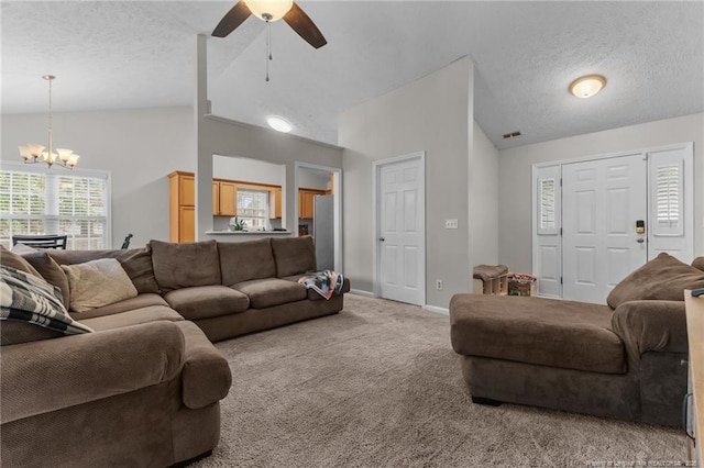 living area with vaulted ceiling, a chandelier, carpet floors, ceiling fan, and a textured ceiling