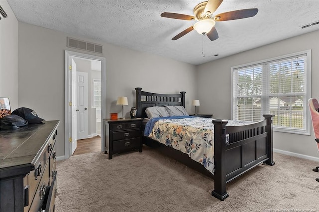 carpeted bedroom featuring a textured ceiling, baseboards, and ceiling fan