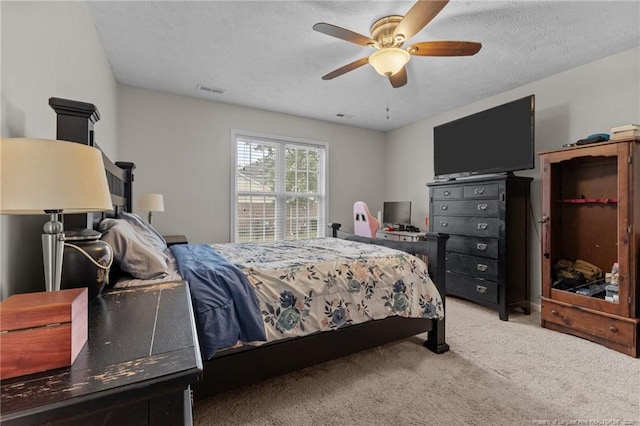 bedroom featuring carpet, a textured ceiling, and a ceiling fan