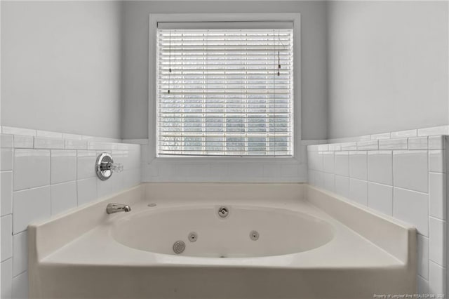 bathroom with a tub with jets