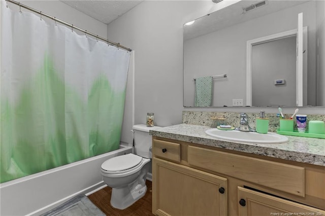 full bathroom with toilet, vanity, wood finished floors, shower / tub combo with curtain, and a textured ceiling