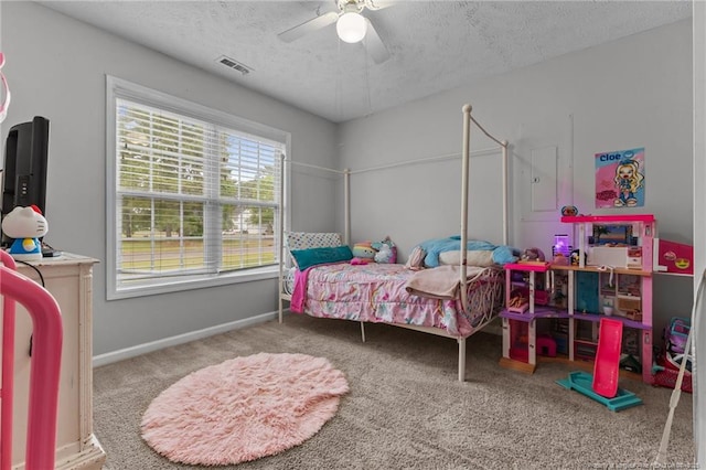 carpeted bedroom with a textured ceiling, baseboards, and a ceiling fan