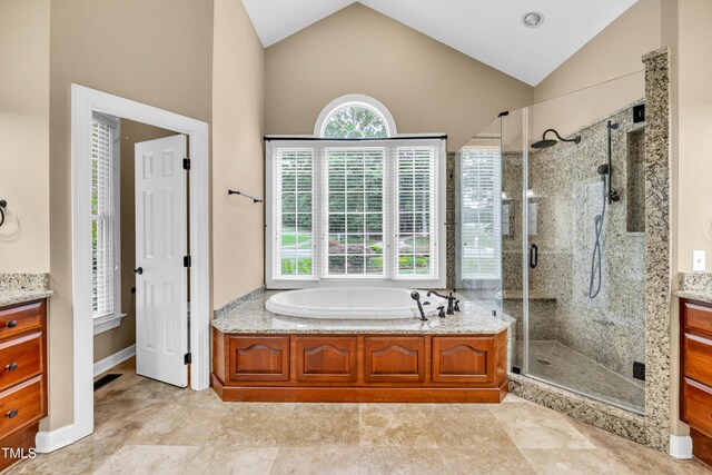 608 Greyrock Rd, Whitsett, NC 27377 - bathroom featuring vanity, lofted ceiling, a stall shower, and a garden tub