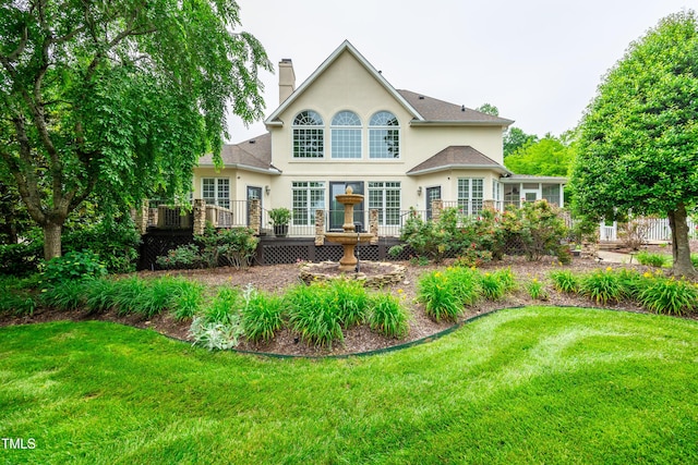 608 Greyrock Rd, Whitsett, NC 27377 - back of property with stucco siding, a deck, a lawn, and a chimney