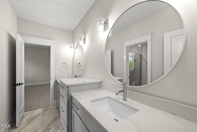 7417 Dover Hills Dr Unit 73, Wake Forest, NC 27587 - bathroom with marble look tiles, two vanities, and baseboards