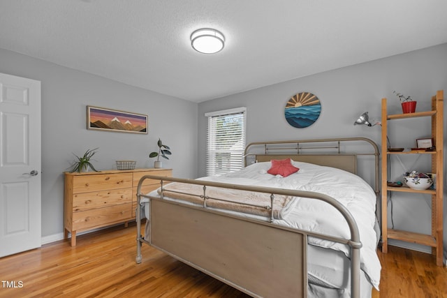 bedroom with light wood-type flooring and baseboards