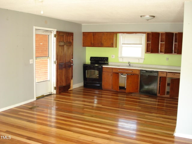 6383 Elevation Rd, Benson, NC 27504 - kitchen featuring dishwashing machine, black range with electric cooktop, light wood-style floors, light countertops, and brown cabinets