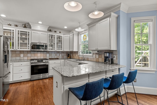 100 Michaels Way, Chapel Hill, NC 27516 - kitchen with stainless steel appliances, a sink, a peninsula, tasteful backsplash, and crown molding