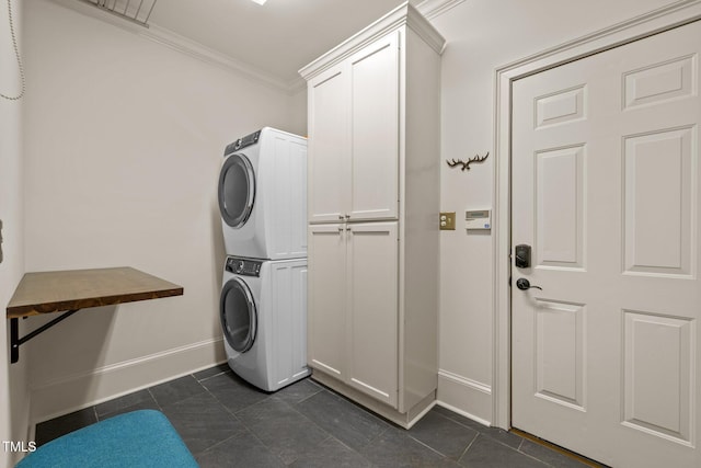 100 Michaels Way, Chapel Hill, NC 27516 - washroom with stacked washer / dryer, crown molding, baseboards, dark tile patterned flooring, and cabinet space