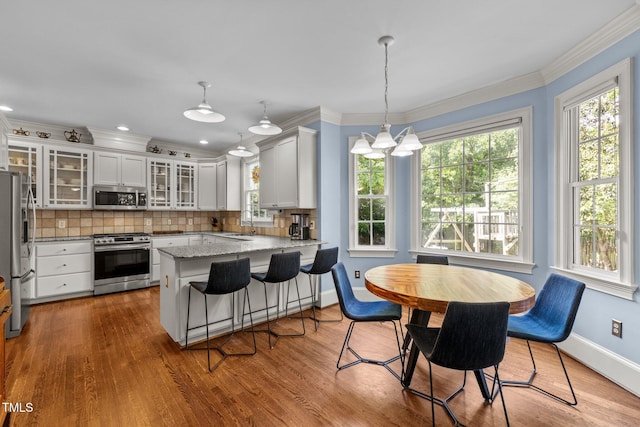 100 Michaels Way, Chapel Hill, NC 27516 - kitchen with appliances with stainless steel finishes, a peninsula, decorative backsplash, wood finished floors, and baseboards