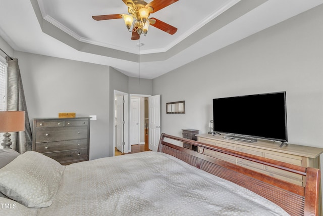 bedroom featuring a raised ceiling, crown molding, and ceiling fan