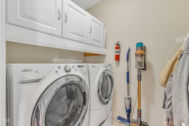 washroom featuring cabinet space and washing machine and clothes dryer