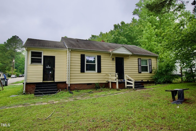 view of front of property featuring entry steps, a front yard, crawl space, and roof with shingles