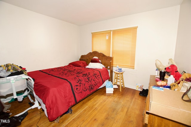 bedroom with wood finished floors and baseboards