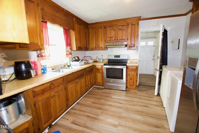 kitchen featuring stainless steel range with electric stovetop, under cabinet range hood, a sink, washing machine and dryer, and light countertops