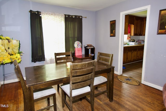 dining space featuring wood finished floors and baseboards