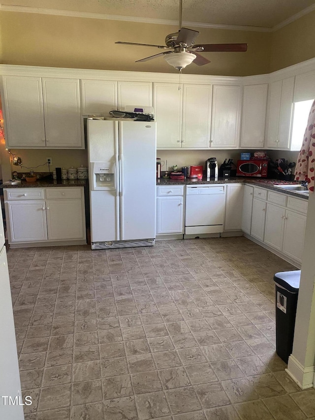 kitchen with white appliances, ceiling fan, dark countertops, white cabinetry, and crown molding