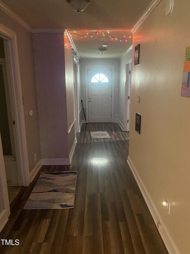 corridor featuring ornamental molding, wood finished floors, and baseboards