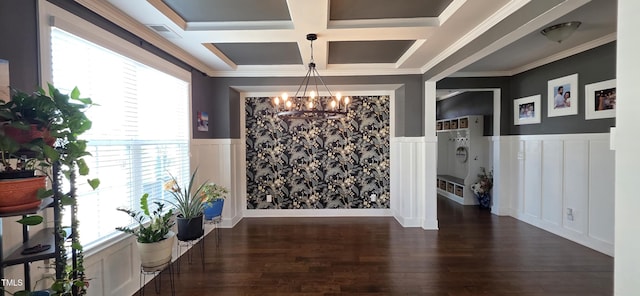dining area with a chandelier, coffered ceiling, a wainscoted wall, wood finished floors, and a decorative wall