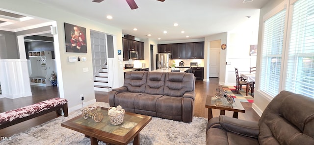 living room featuring stairs, a ceiling fan, healthy amount of natural light, recessed lighting, and dark wood-type flooring
