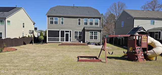 back of house with a playground and a sunroom