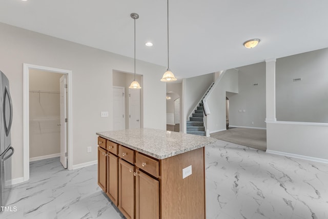 5025 Stonewood Pines Dr, Knightdale, NC 27545 - kitchen featuring light marble finish floors, a kitchen island, pendant lighting, brown cabinets, and baseboards