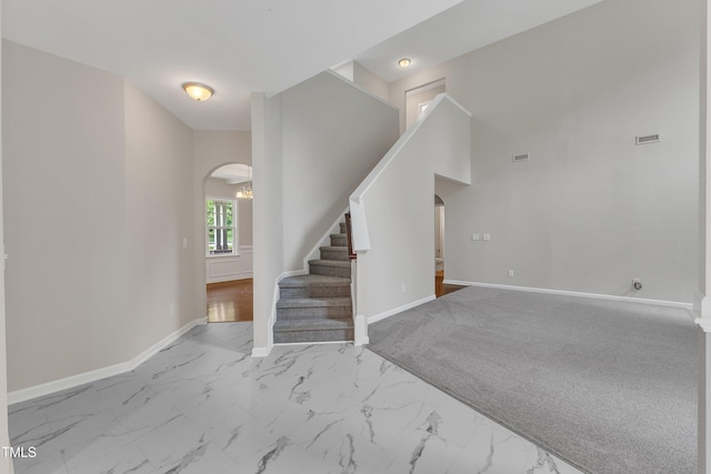 5025 Stonewood Pines Dr, Knightdale, NC 27545 - staircase with arched walkways, baseboards, and marble look tile flooring