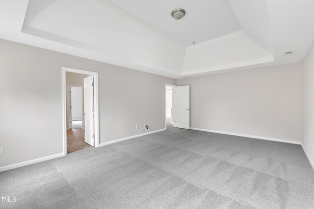 5025 Stonewood Pines Dr, Knightdale, NC 27545 - spare room featuring a tray ceiling, carpet flooring, and baseboards