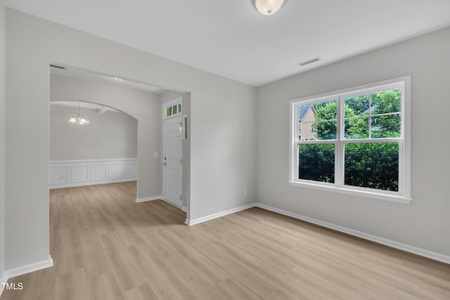 5025 Stonewood Pines Dr, Knightdale, NC 27545 - unfurnished room with light wood-type flooring, a chandelier, arched walkways, and baseboards