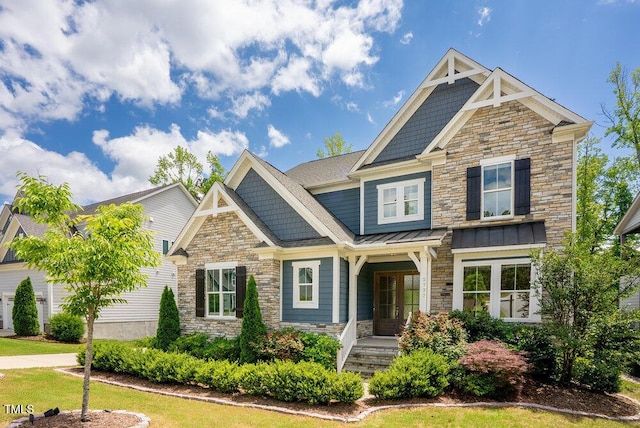 craftsman house featuring stone siding, a standing seam roof, french doors, and metal roof