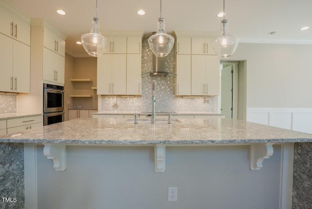 kitchen with stainless steel double oven, a kitchen bar, pendant lighting, backsplash, and recessed lighting