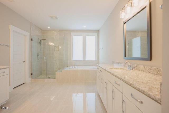 bathroom with a stall shower, a garden tub, vanity, tile patterned flooring, and recessed lighting