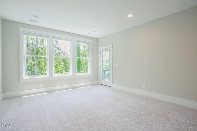 carpeted spare room featuring plenty of natural light, baseboards, and recessed lighting