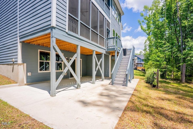 view of side of property with a patio area, stairway, and a deck