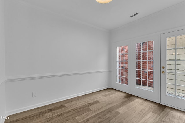 unfurnished room featuring ornamental molding, wood finished floors, plenty of natural light, and baseboards