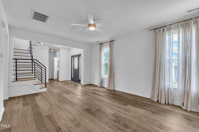 entrance foyer featuring ceiling fan, stairs, wood finished floors, and baseboards