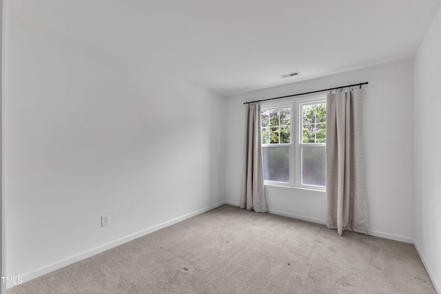 carpeted empty room featuring baseboards