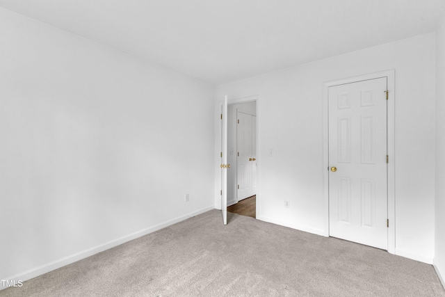 unfurnished bedroom with carpet flooring and baseboards