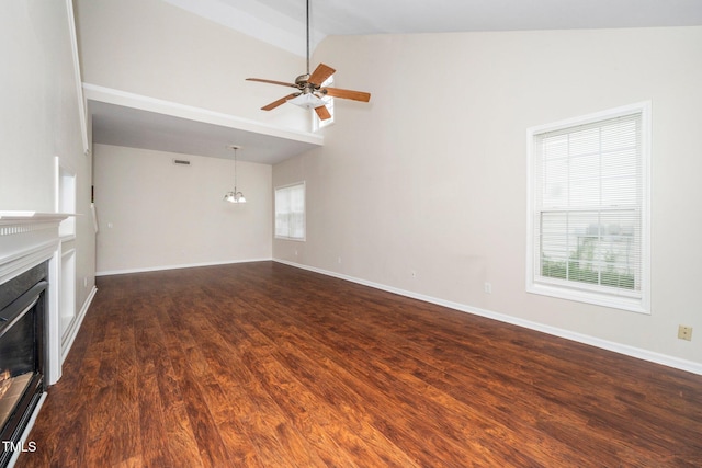 unfurnished living room featuring a fireplace, a ceiling fan, dark wood-style flooring, baseboards, and a chandelier