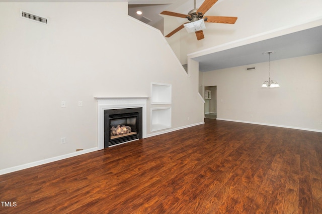 unfurnished living room featuring a ceiling fan, high vaulted ceiling, a fireplace, wood finished floors, and baseboards