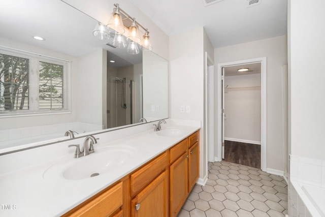 bathroom with a bath, double vanity, and a shower