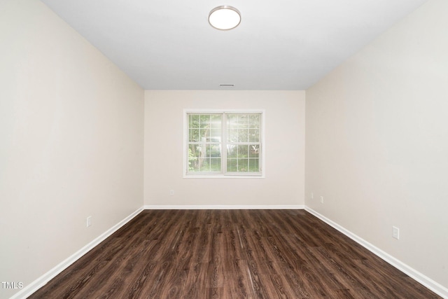 empty room featuring dark wood finished floors and baseboards