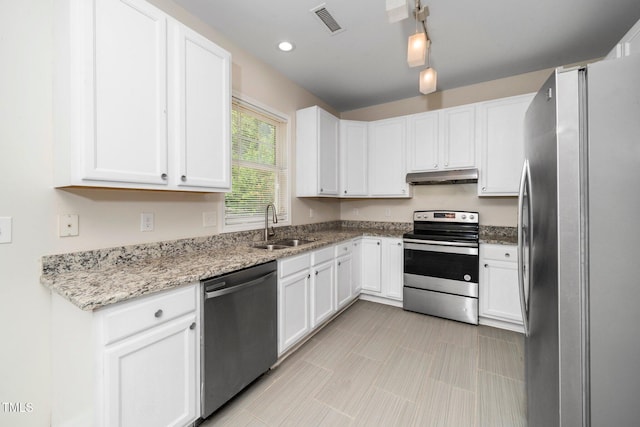 kitchen featuring stainless steel appliances, under cabinet range hood, a sink, white cabinets, and light stone counters